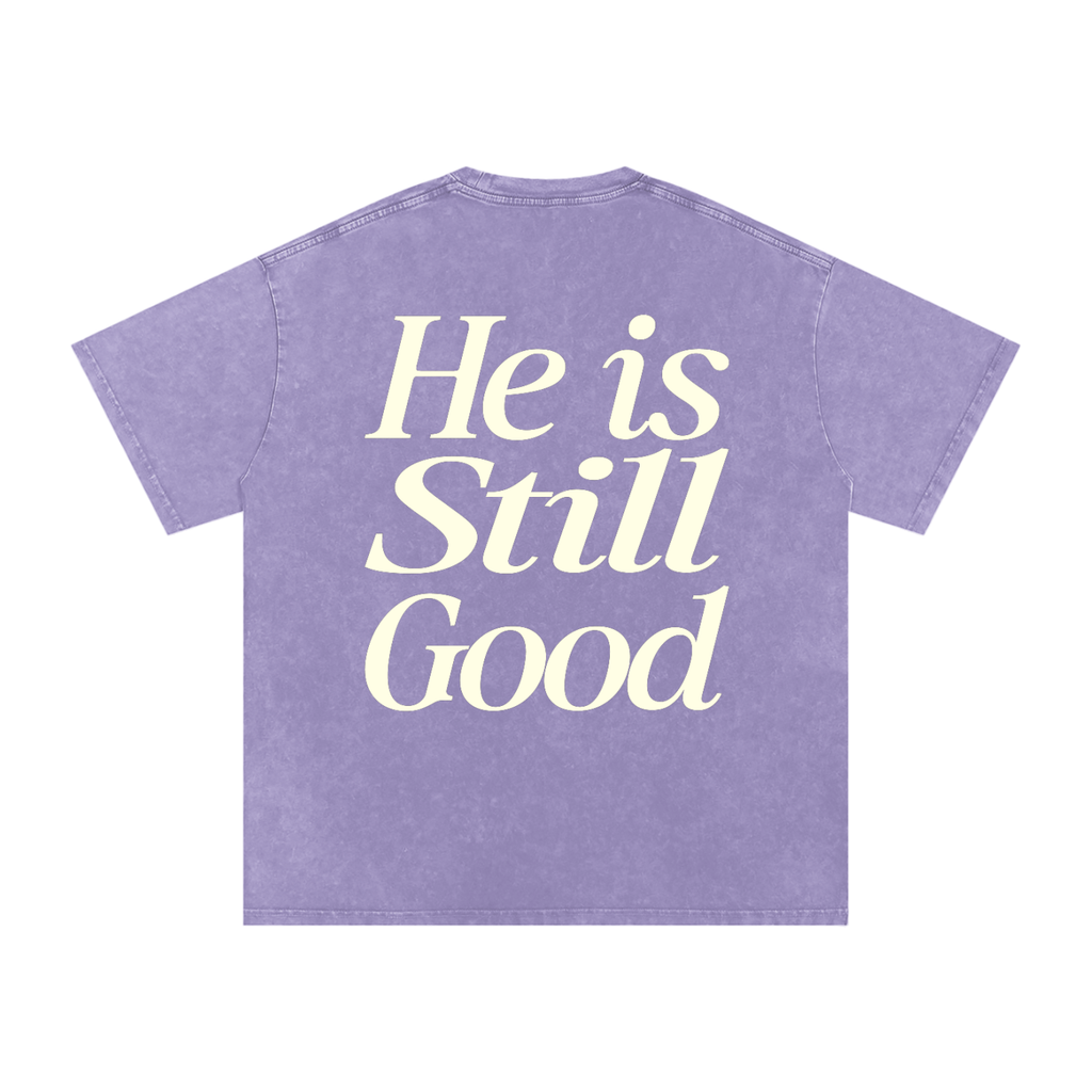 Purple t-shirt with 'He is Still Good' text on a white background